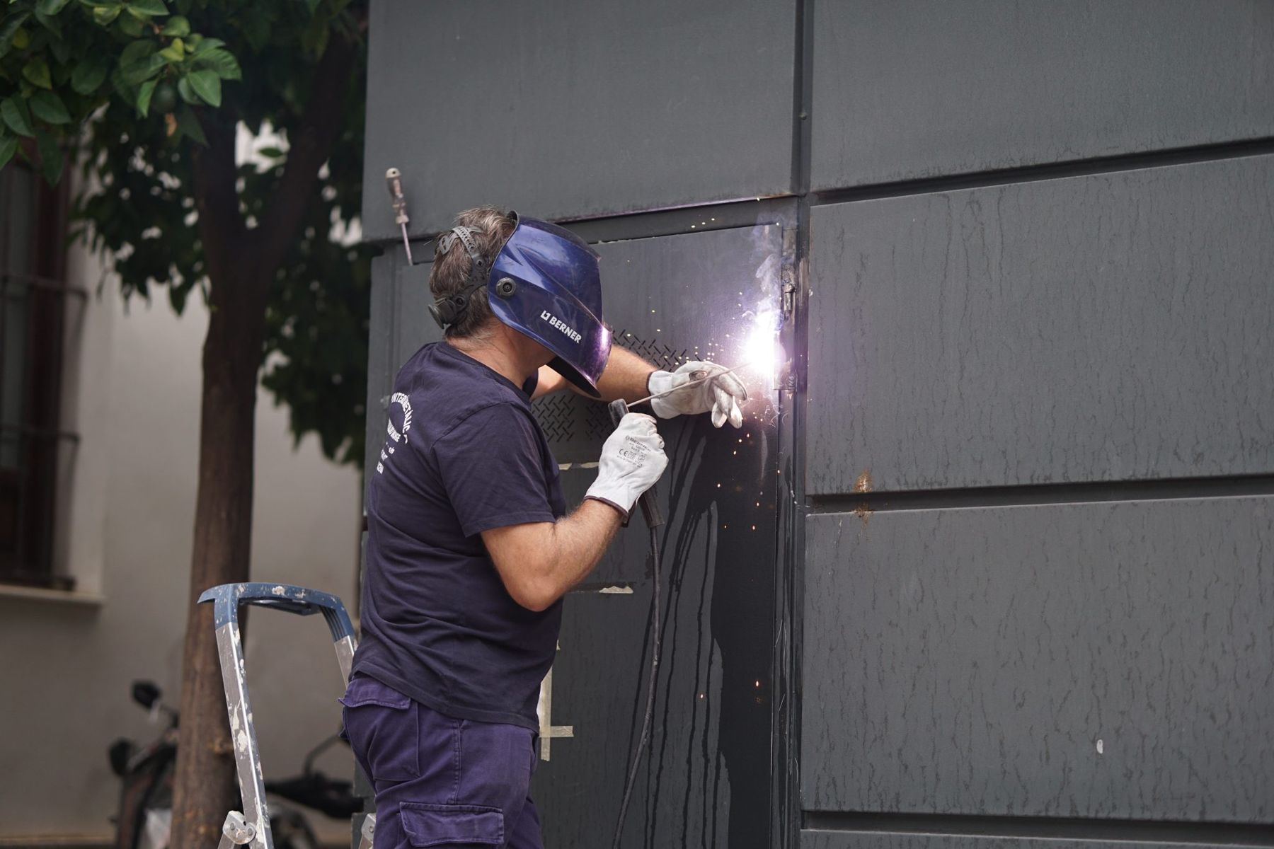 Technician welding a steel gate on site